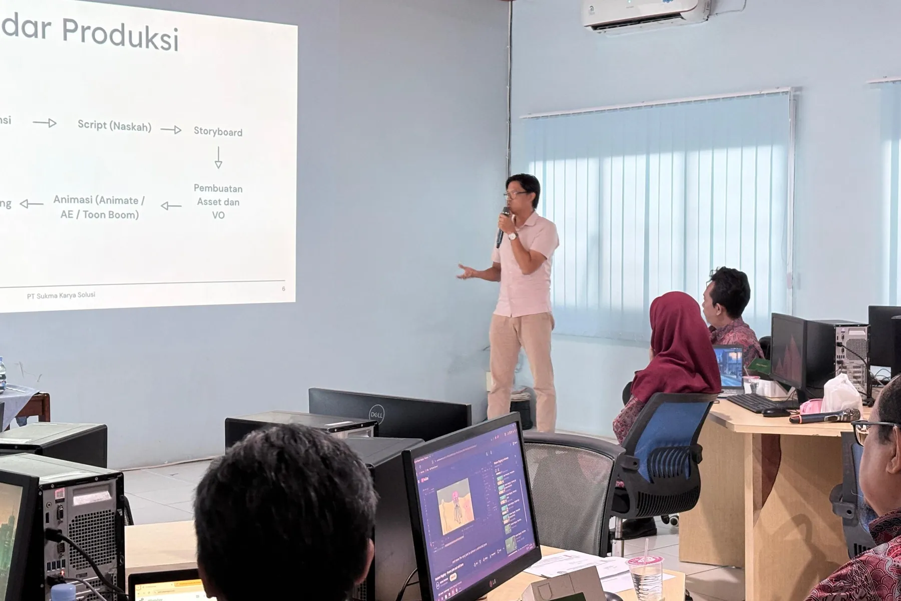 A Sukma Karya Solusi trainer presenting an animation production workflow to participants in a computer lab